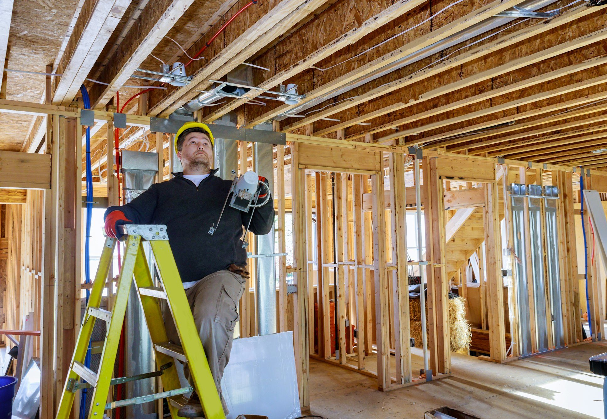 Electrician is holding in his hands installs and mounts the interior lighting on the ceiling