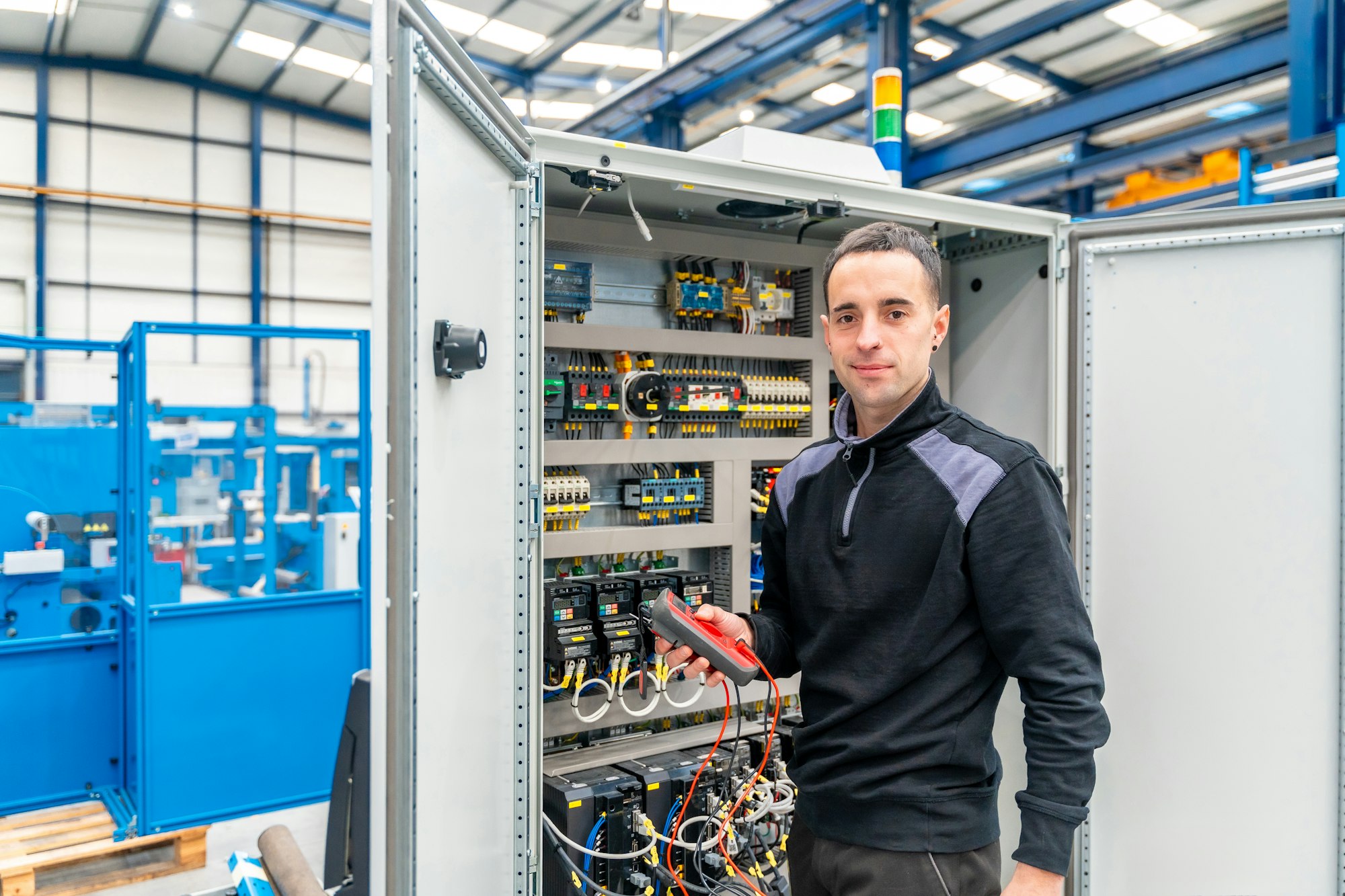 Technician repairing an electrical mechanical system in a factory